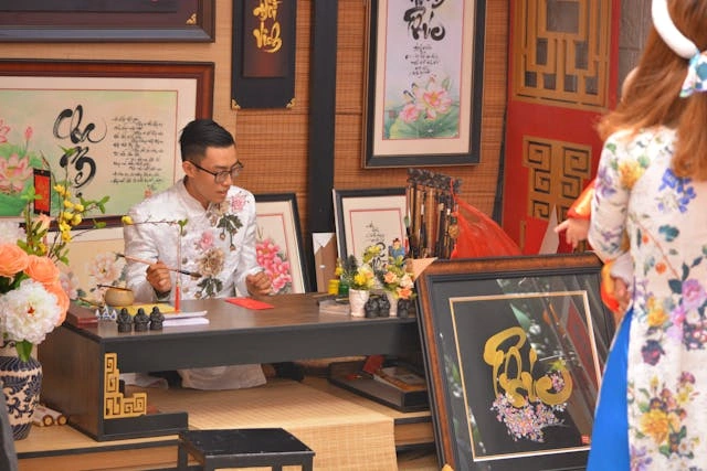 Mies ja nainen pöydän ääressä keskittyvät kiinalaiseen kalligrafiaan luoden kulttuurisen ja taiteellisen tunnelman.myyntifunneli